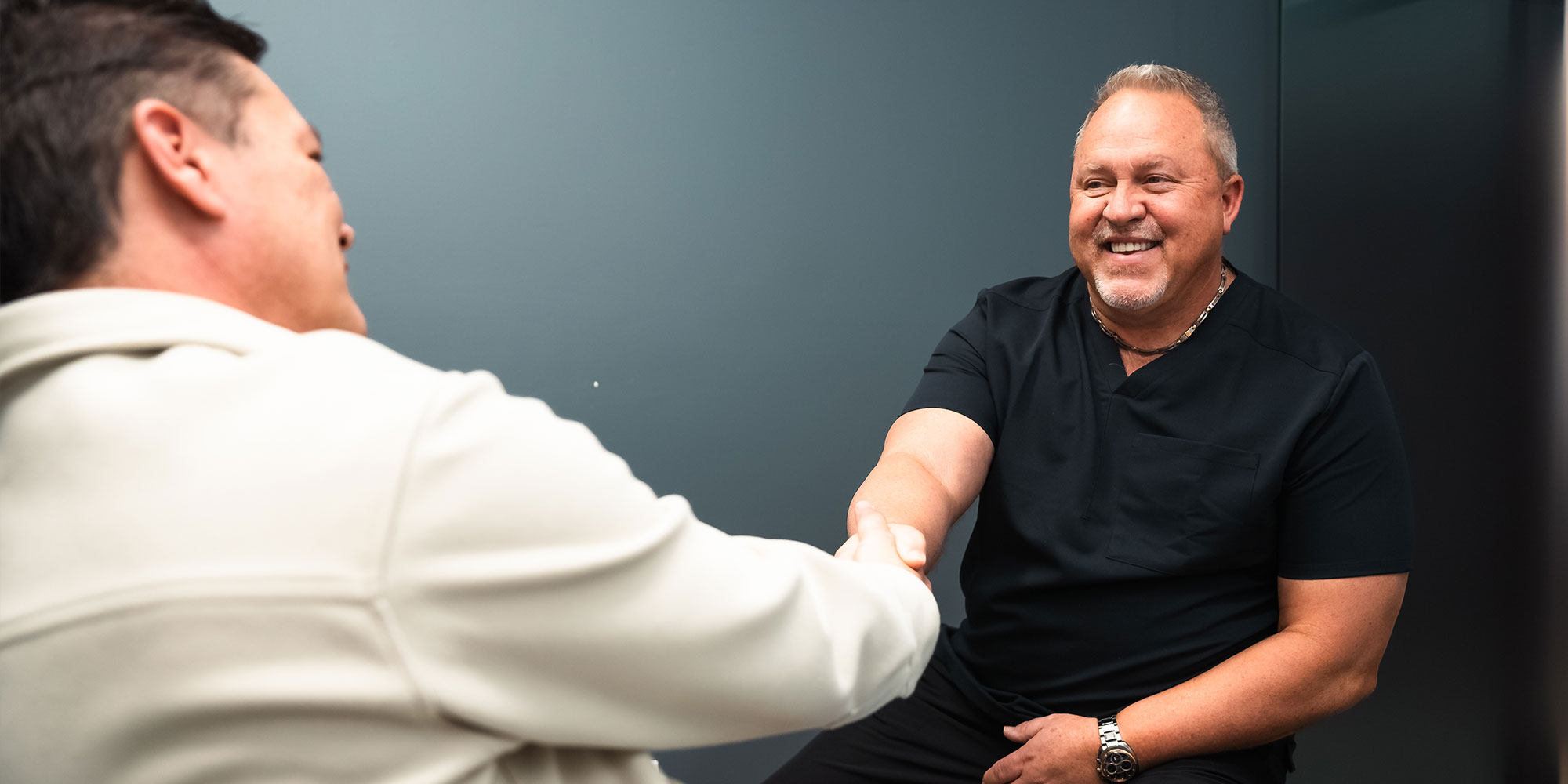 patient shaking doctors hand after dental implant consultation